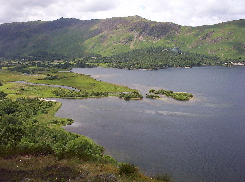 Aerial view of Crummock Water with surrounding green hills and scattered clouds.