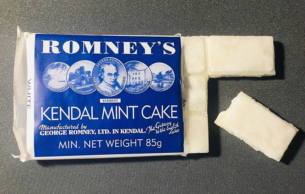 Romney's Kendal Mint Cake packaging with broken pieces on a dark surface.