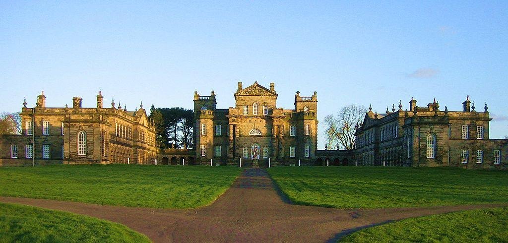 Seaton Delaval Hall | Wide view of the grand, symmetrical facade of Seaton Delaval Hall, with an expansive, well-maintained lawn in the foreground.