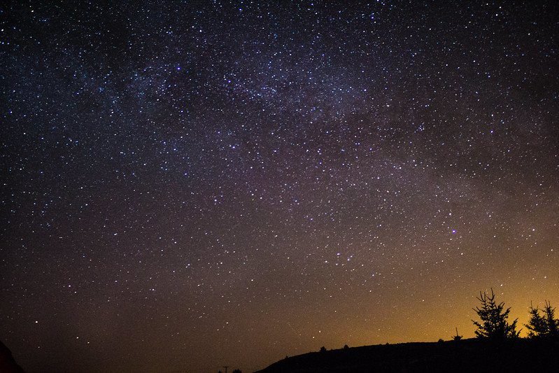 Kielder Water & Forest Park | Starry night sky over a silhouetted landscape.