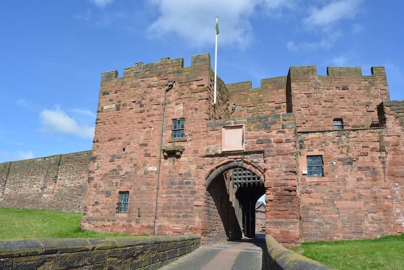 Carlisle Castle, A stone castle gatehouse with crenellations, an arched entrance, and a flag on top.