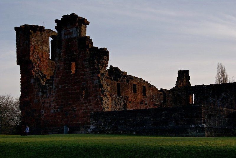 Silhouette of a historic stone castle ruin against a twilight sky.