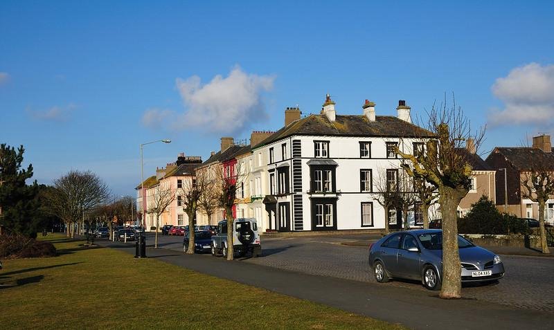 Silloth, Cumbria, A Street with parked cars and a row of colourful terraced houses on a sunny day.