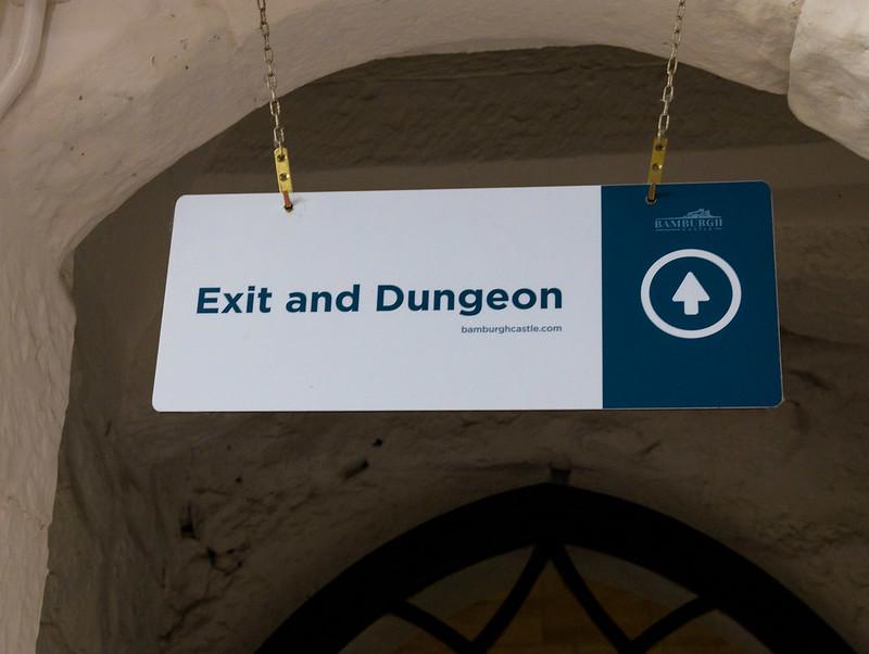 Sign labeled "Exit and Dungeon" with an upward arrow.