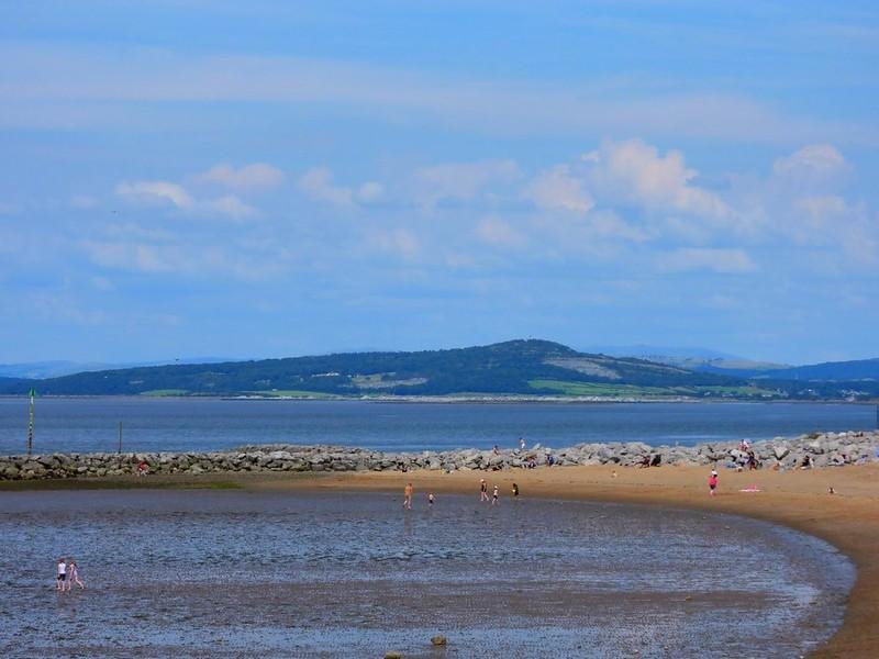 Morecambe Bay | People enjoying the beach with a view of hills and the sea in the background.