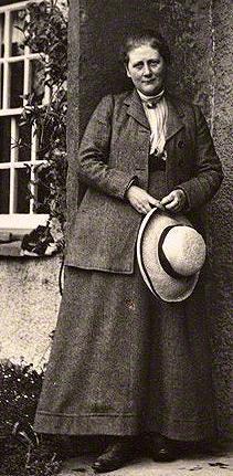 Beatrix Potter, A Woman standing outdoors holding a hat.