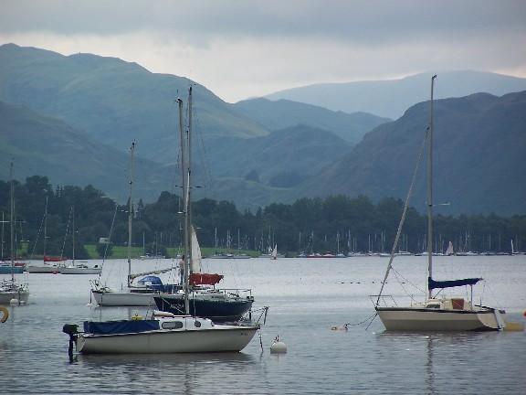 Sailboats on a lake with mountains in the background.